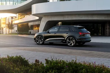 Vista lateral del Audi Q8 e-tron mostrando su elegante diseño y línea dinámica.