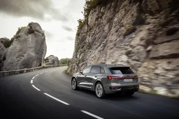 Imagen dinámica del Audi Q8 e-tron mostrando su perfil lateral mientras circula.
