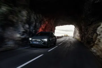 Audi Q8 e-tron emergiendo de un túnel, destacando su frontal LED.