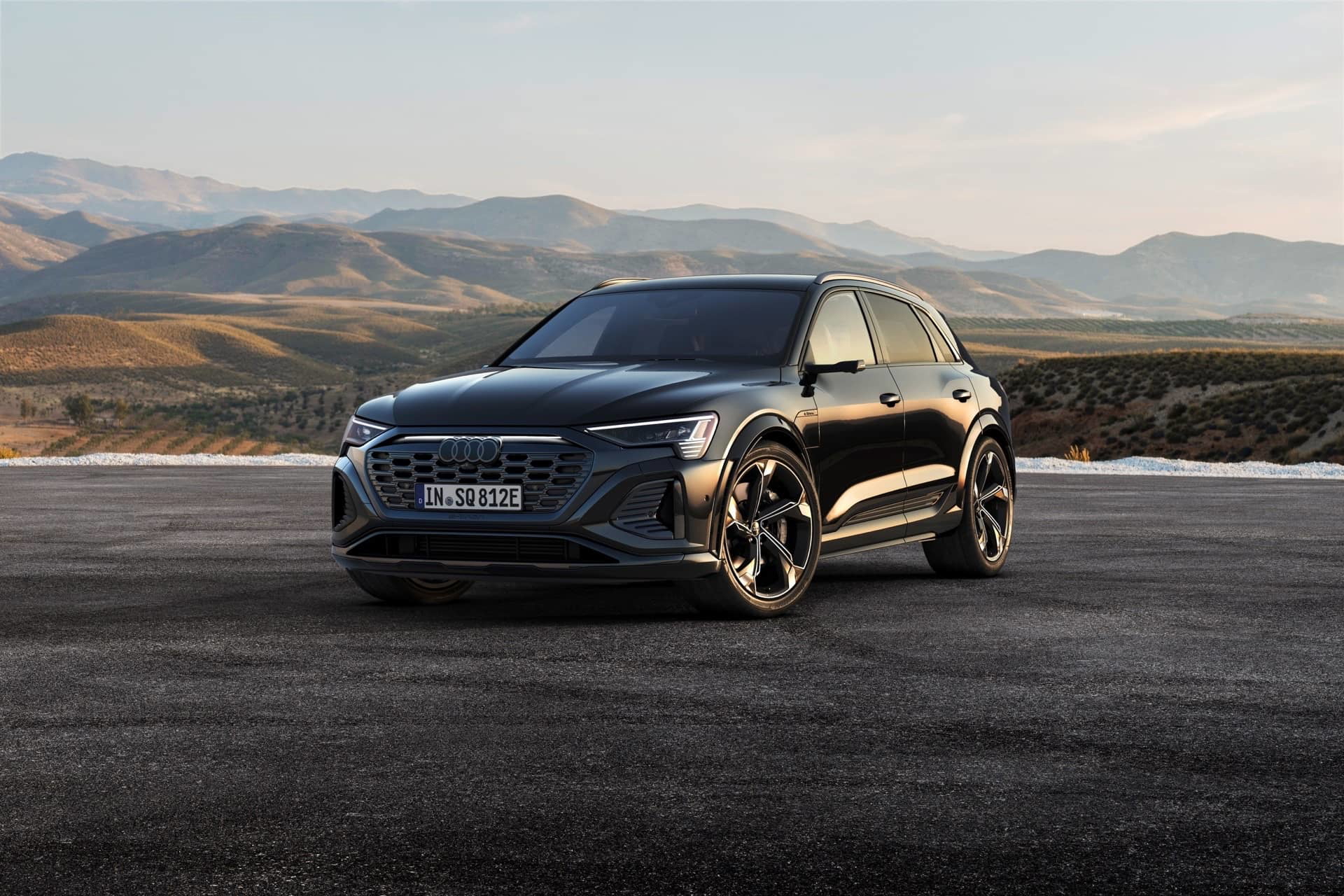 Vista dinámica del Audi Q8 e-tron destacando su imponente frontal y línea lateral.