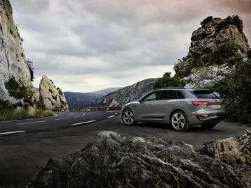 Vista dinámica del Audi Q8 e-tron en un entorno de carretera de montaña.