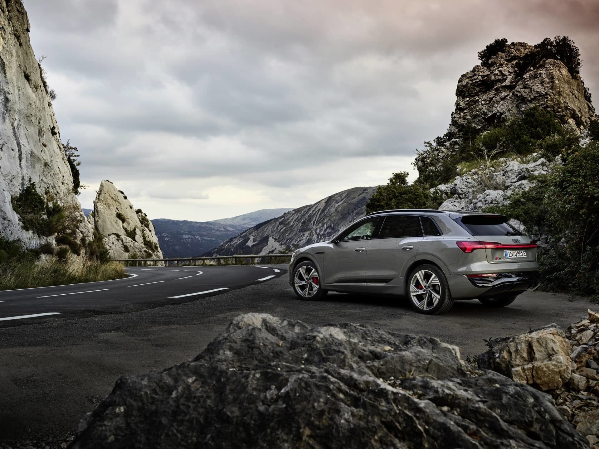 Vista dinámica del Audi Q8 e-tron en un entorno de carretera de montaña.