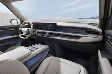 Vista lateral del salpicadero y asientos delanteros del KIA EV9, destacando su diseño moderno y espacioso.