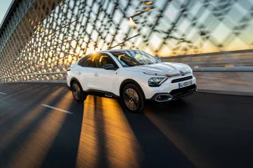 Vista dinámica del Citroën C4 X en movimiento urbano, destacando su diseño frontal