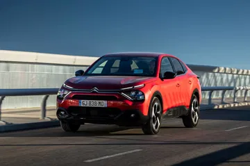 Citroën C4 X en acabado rojo exhibiendo su diseño frontal y lateral.