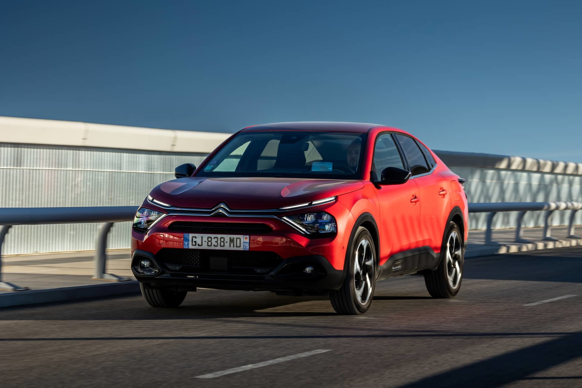 Citroën C4 X en acabado rojo exhibiendo su diseño frontal y lateral.