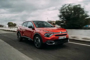 Vista lateral del Citroën C4 X en movimiento, destacando su diseño fluido.