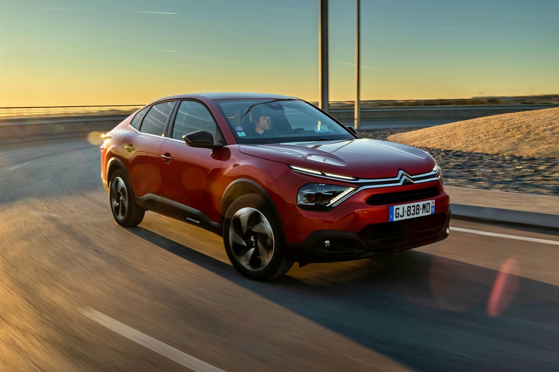 Vista lateral del Citroën C4 X resaltando su diseño aerodinámico y líneas fluidas.