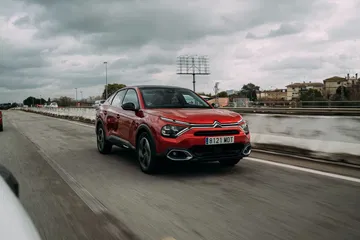 Dinámica toma lateral del Citroën C4 X en movimiento, diseño fluído.