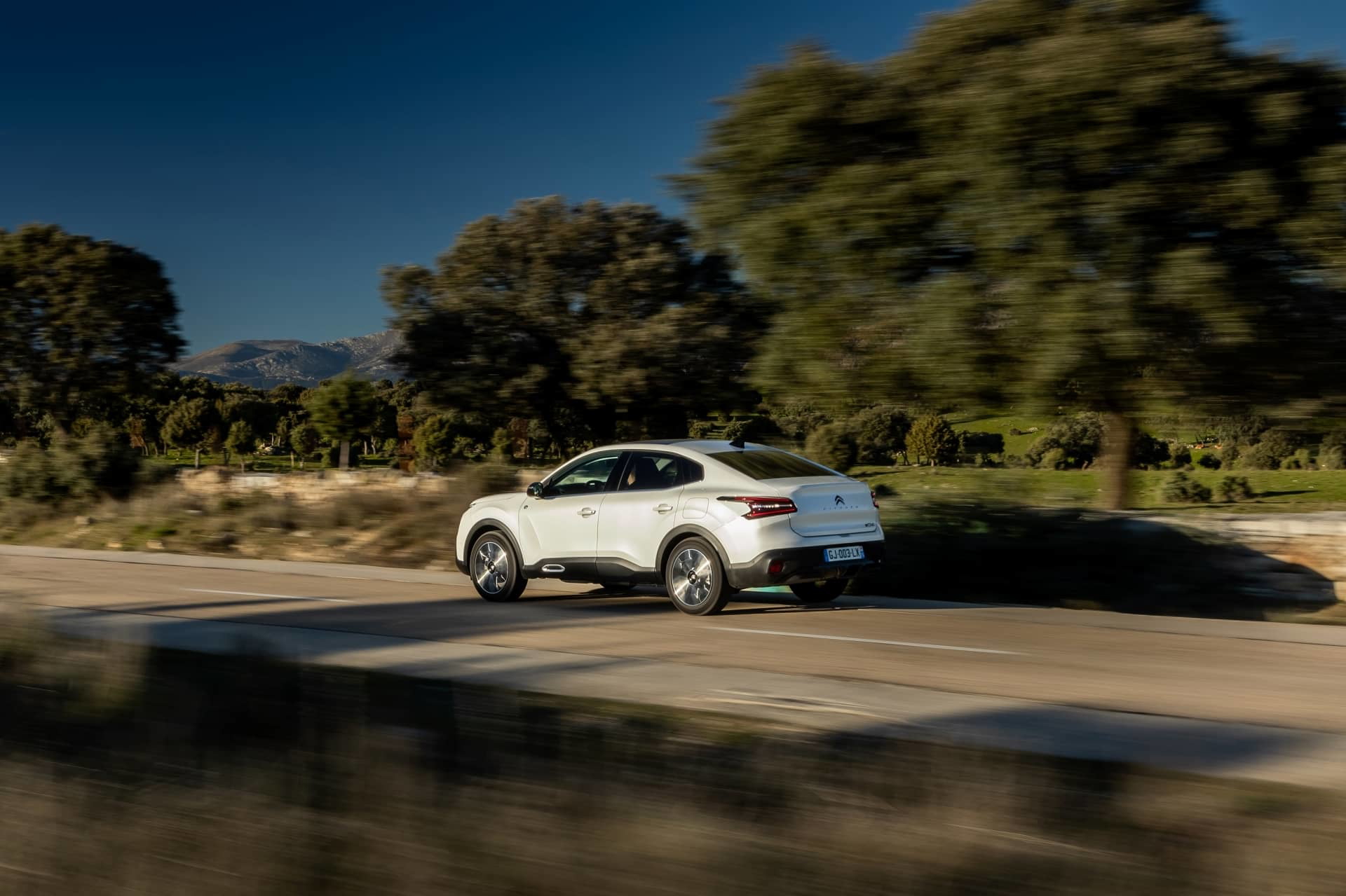 Vista dinámica del Citroën C4 X en movimiento, mostrando su perfil.