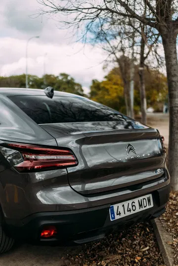 Vista de perfil trasero del Citroën C4 X, destacando su diseño y luces.