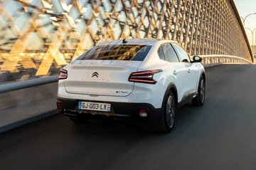 Vista dinámica del Citroën C4 X mostrando su diseño trasero y lateral.