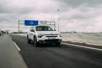 Citroën C4 X circulando por carretera, vista dinámica frontal y lateral.