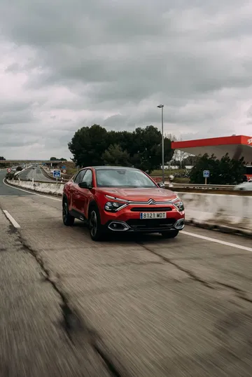 Vista lateral del Citroën C4 X en movimiento sobre carretera.