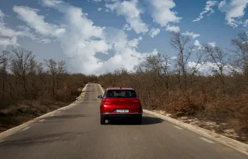 Vista trasera del DFSK 500 en carretera, mostrando líneas y faros.