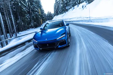 Ferrari Purosangue conquistando curvas nevadas con elegancia y dinamismo.