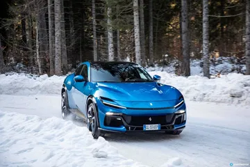 Vista delantera lateral del Ferrari Purosangue sobre un manto de nieve.