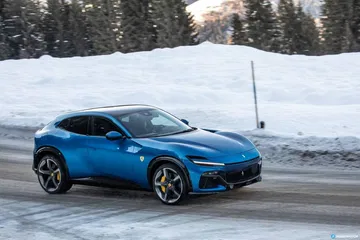 Vista lateral del Ferrari Purosangue azul en prueba de carretera nevada.