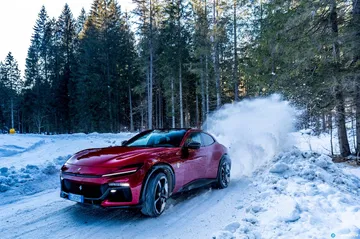 Ferrari Purosangue deslizándose con elegancia sobre un camino nevado.