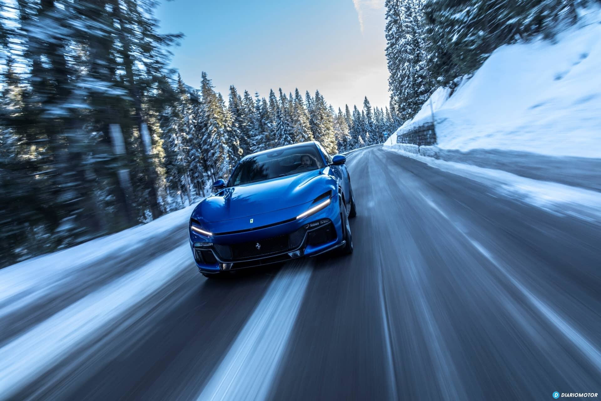 Ferrari Purosangue azul en carretera nevada, mostrando su diseño frontal y lateral.