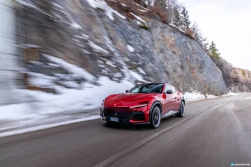 Ferrari Purosangue glisse avec élégance sur une route enneigée. Ferrari Purosangue glisse avec élégance sur une route enneigée.