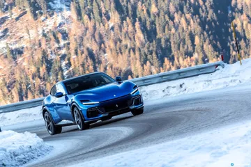 Vista dinámica lateral del Ferrari Purosangue en condiciones de nieve.