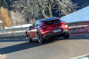 Vista lateral del Ferrari Purosangue en movimiento, destacando su línea aerodinámica.