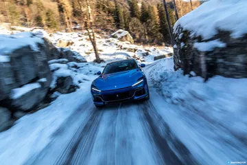 Vista frontal del Ferrari Purosangue avanzando por una carretera nevada.