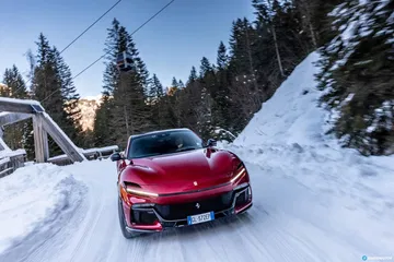 Vista trasera lateral del Ferrari Purosangue en un paisaje nevado.