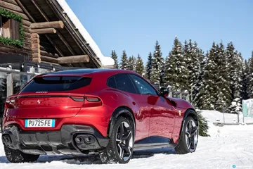 Vista trasera lateral del Ferrari Purosangue en un entorno nevado.