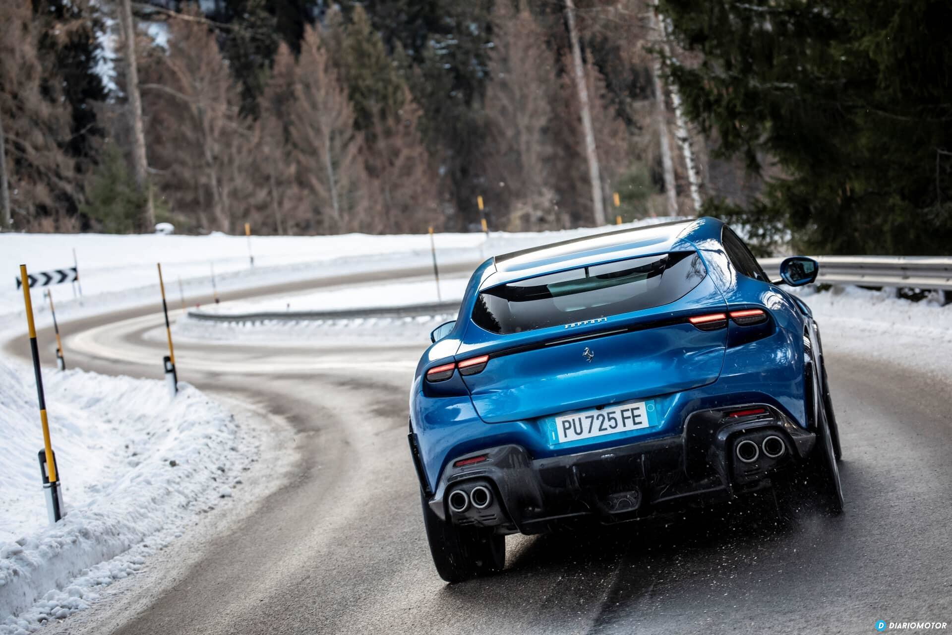 Ferrari Purosangue azul tomado desde angulo delantero-lateral en carretera nevada