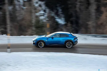 Vista lateral Ferrari Purosangue en paisaje invernal.