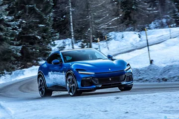 Vista lateral del Ferrari Purosangue en un entorno nevado.