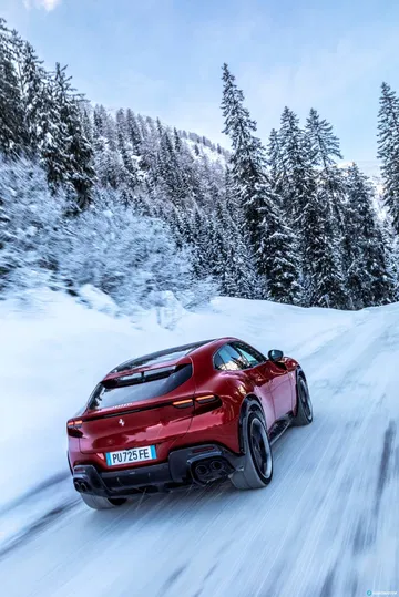 Vista lateral trasera del Ferrari Purosangue en un paisaje nevado.