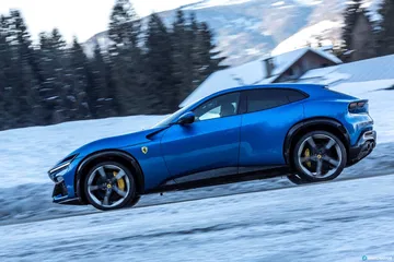 Vista lateral del Ferrari Purosangue en un entorno nevado, destacando su silueta deportiva