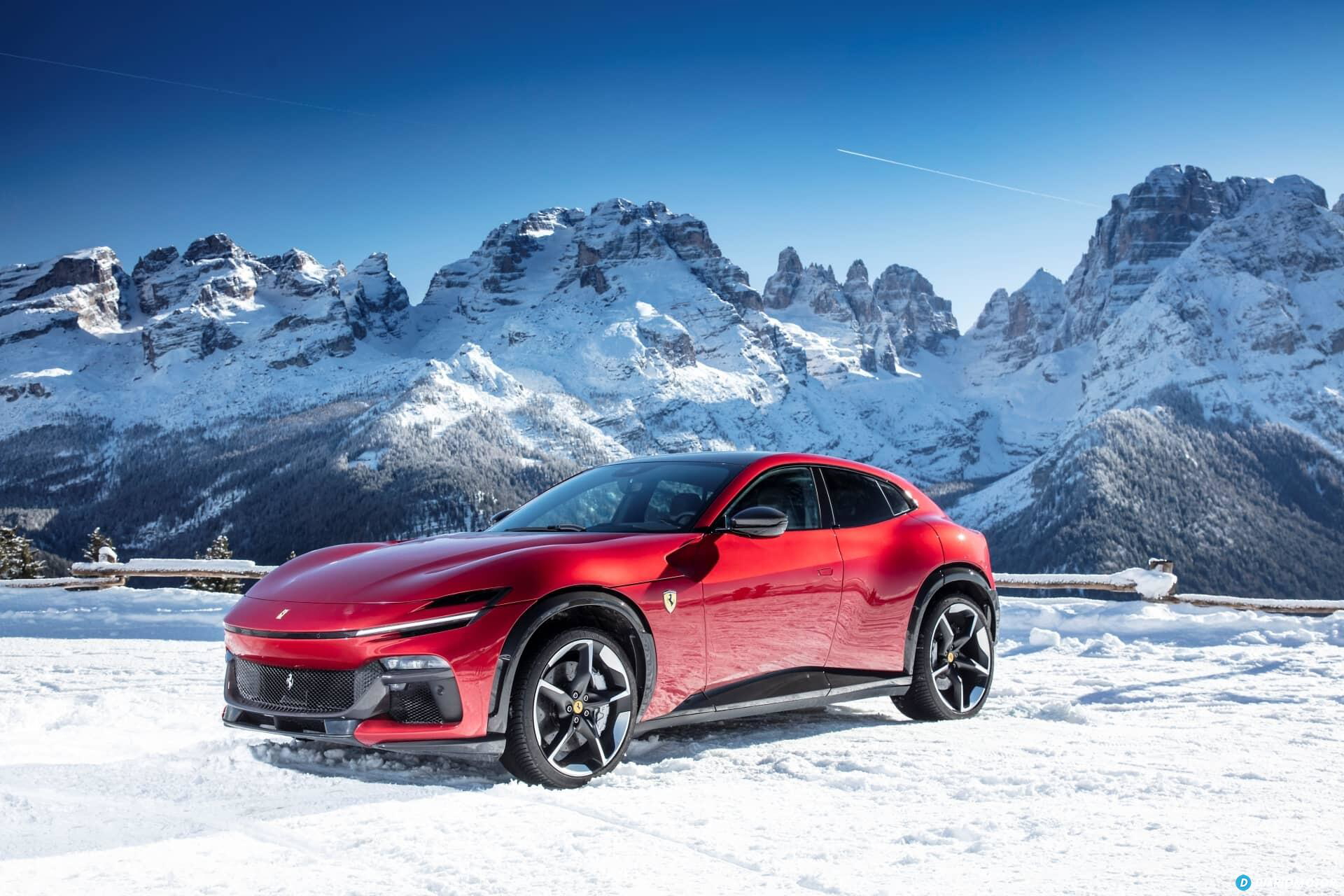 Vista lateral del Ferrari Purosangue sobre fondo de montañas nevadas.