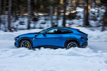 Vista lateral del Ferrari Purosangue en un entorno nevado.