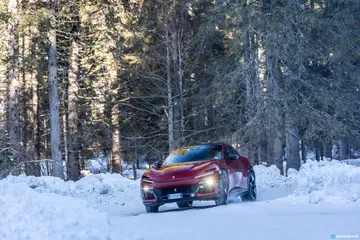 Vista lateral del Ferrari Purosangue en un paisaje nevado.