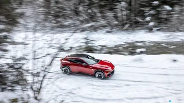 Ferrari Purosangue dominando terrenos nevados con su perfil lateral potente.