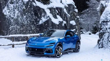 Vista lateral del Ferrari Purosangue en un entorno nevado.