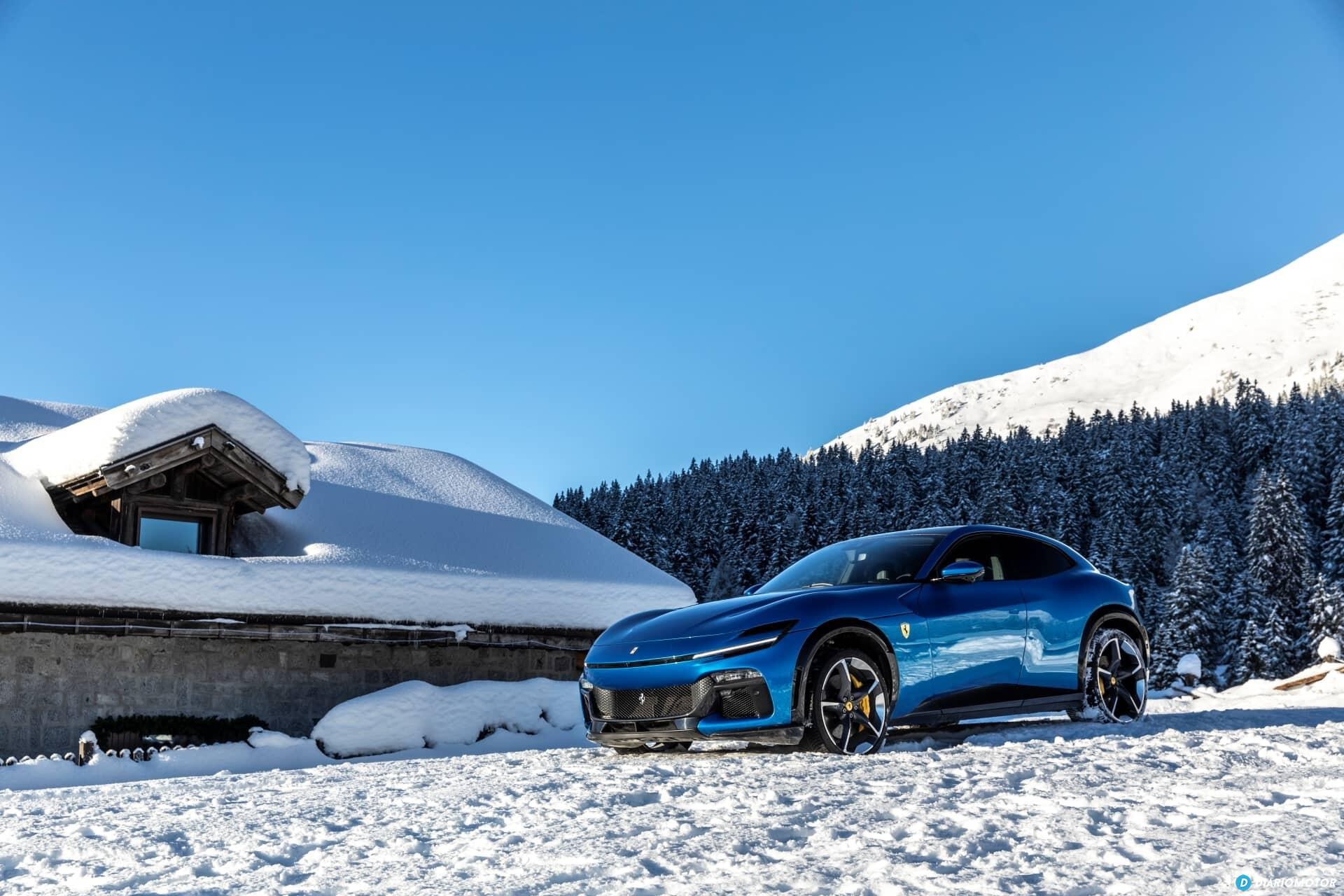 Vista lateral del Ferrari Purosangue sobre la nieve con montañas al fondo.