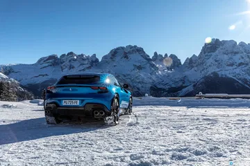 Vista lateral del Ferrari Purosangue revelando su diseño fluido y deportivo sobre la nieve.