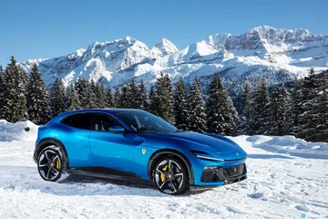 Vista lateral del Ferrari Purosangue sobre un paisaje nevado.