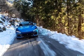 Vista delantera y lateral del Ferrari Purosangue en entorno nevado.