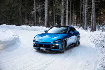 Vista frontal y lateral del Ferrari Purosangue en un paisaje nevado.