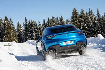 Vista lateral del Ferrari Purosangue sobre un paisaje nevado, destacando su silueta deportiva
