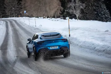 Ferrari Purosangue dominando la carretera nevada con elegancia.