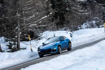 Vista lateral del Ferrari Purosangue conquistando una carretera nevada