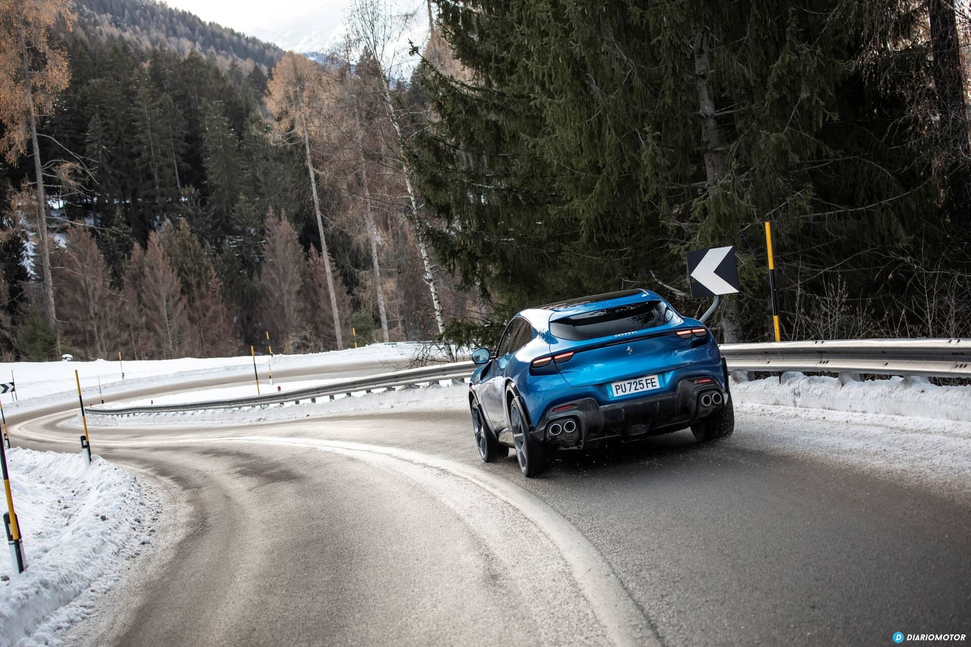 Vista trasera lateral del Ferrari Purosangue destacando en un paisaje nevado.