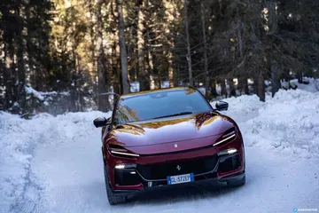 Ferrari Purosangue destacando su diseño frontal y lateral en un ambiente nevado.